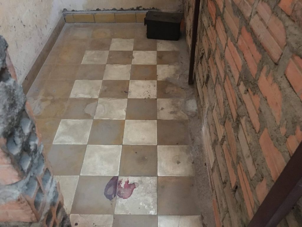 Cella di un detenuto, nel pavimento si possono notare le chiazze di sangue